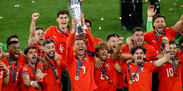 Portugal's forward #07 Cristiano Ronaldo (C) lifts the trophy after winning the UEFA Nations League final football match between Portugal and Spain in Munich, southern Germany on June 8, 2025. (Photo by Alexandra BEIER / AFP)