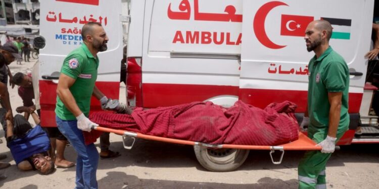 EDITORS NOTE: Graphic content / Medics carry casualties of reported Israeli strikes on members of aid security committees set up by volunteers from prominent Palestinian families to prevent aid theft, in the Saftawi neighborhood west of Jabalia in the northern Gaza Strip on August 13, 2025. The Israeli military said it had approved the framework for a new offensive in the Gaza Strip, days after Israel's security cabinet called for the seizure of Gaza's largest city, following 22 months of war that have created dire humanitarian conditions in the Palestinian territory. (Photo by Bashar TALEB / AFP)