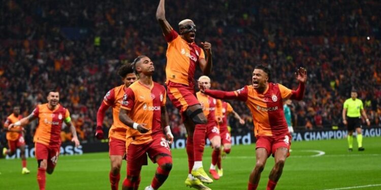 Galatasaray's Gabonese midfielder #99 Mario Lemina (L) celebrates with Galatasaray's Nigerian forward #45 Victor Osimhen (C) and Galatasaray's Senegalese defender #04 Ismail Jakobs after scoring the opening goal  during the UEFA Champions League round of 16 first leg football match between Galatasaray SK and Liverpool FC at the Ali Sami Yen Sports Complex in Istanbul on March 10, 2026. (Photo by YASIN AKGUL / AFP)