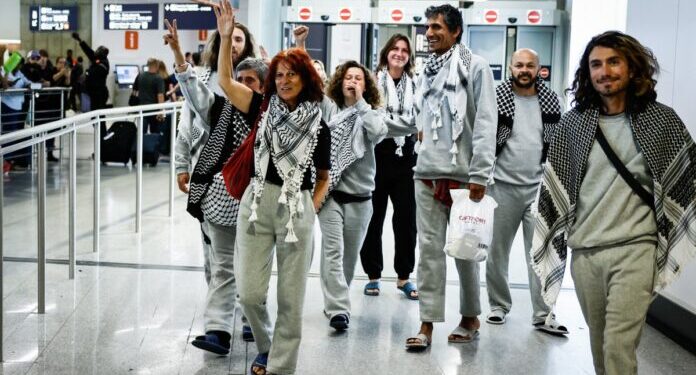 French activists detained and deported by Israel following the interception of their Gaza-bound flotilla arrive at Roissy Charles de Gaulle airport near Paris on May 22, 2026. The 37 French nationals were among some 430 activists from 40 countries aboard the Global Sumud Flotilla, intercepted by the Israeli navy in international waters on May 18 in the latest string of attempts to break the blockade of the Palestinian territory. (Photo by SIMON WOHLFAHRT / AFP)