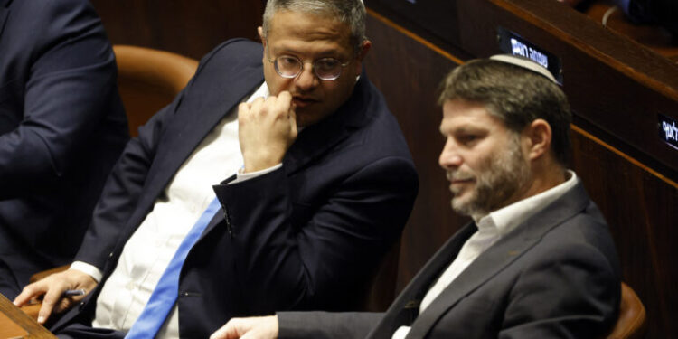Right-wing Knesset members Itamar Ben-Gvir (L) and Bezalel Smotrich, attend a special session at the Knesset Israel's parliament, to approve and swear in a new right-wing government, in Jerusalem on December 29, 2022. The right-wing government, formed after the fifth election in four years, has sparked fears of a further military escalation in the Israeli-occupied West Bank, amid the worst violence there for nearly 20 years. (Photo by AMIR COHEN / POOL / AFP)
