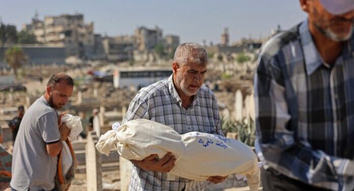 EDITORS NOTE: Graphic content / Family members carry the bodies of the Palestinians who died after an Israeli airstrike targeted a residential apartment in the Sabra neighborhood, during their funeral procession in Gaza City on July 21, 2026. Israeli forces currently control more than 60 percent of the Gaza Strip, where daily violence continues despite a ceasefire between Israel and Palestinian group Hamas. (Photo by Omar AL-QATTAA / AFP)