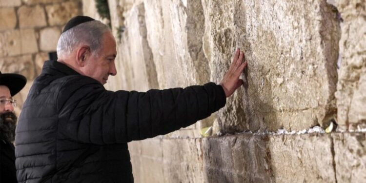 Israel's Prime Minister Benjamin Netanyahu prays as he visits the Western Wall -- the holiest site where Jews are allowed to pray -- to mark the swearing-in of the 37th government of Israel, in the old city of Jerusalem on January 1, 2023. (Photo by GIL COHEN-MAGEN / various sources / AFP)
